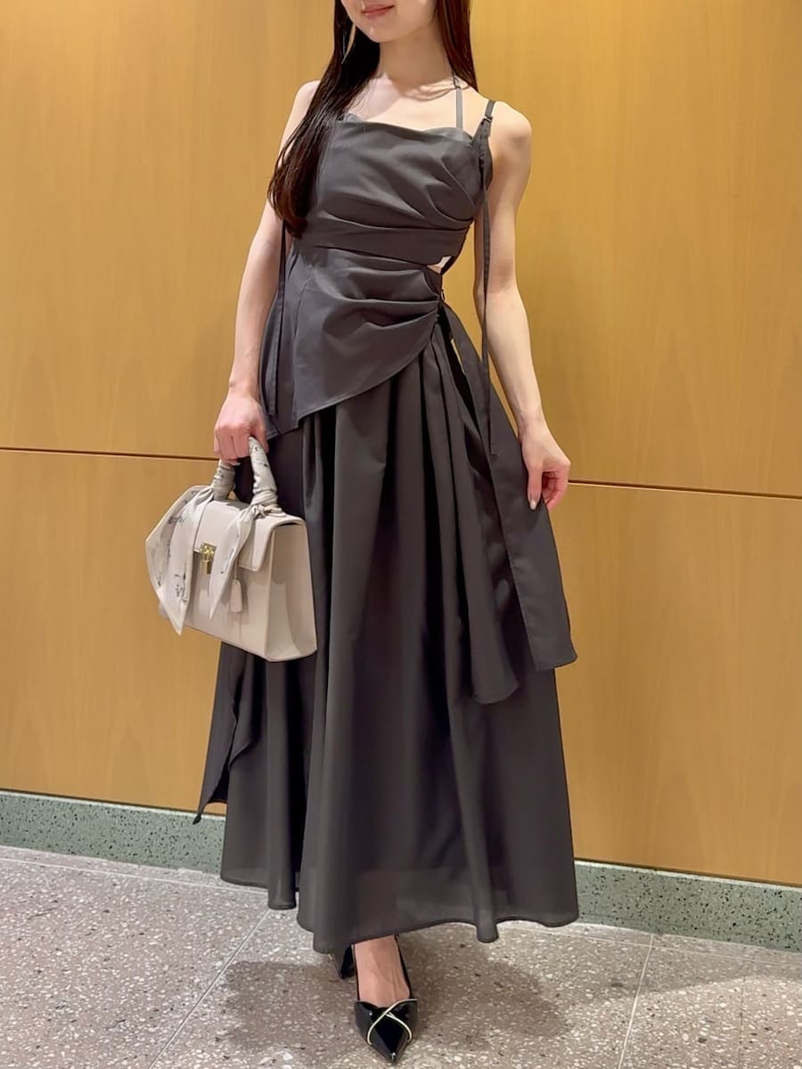 グレー系のワンピース、ブラック系のパンプス、ベージュ系のハンドバッグを着用したレディースの春コーディネートの4枚目の写真