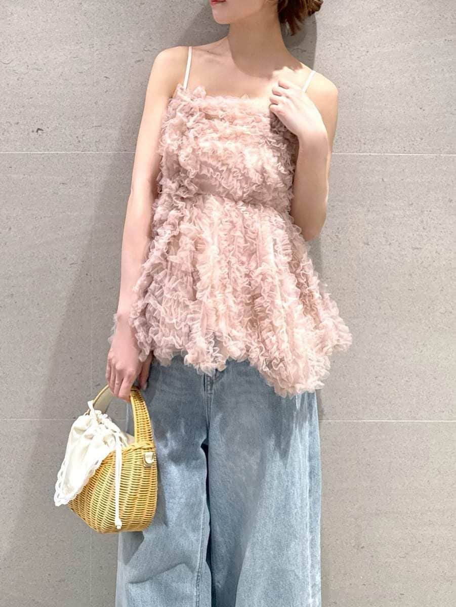 ホワイト系のかごバッグ、ブルー系のデニムパンツ、ブラウン系のサンダルを着用したレディースの夏コーディネートの3枚目の写真