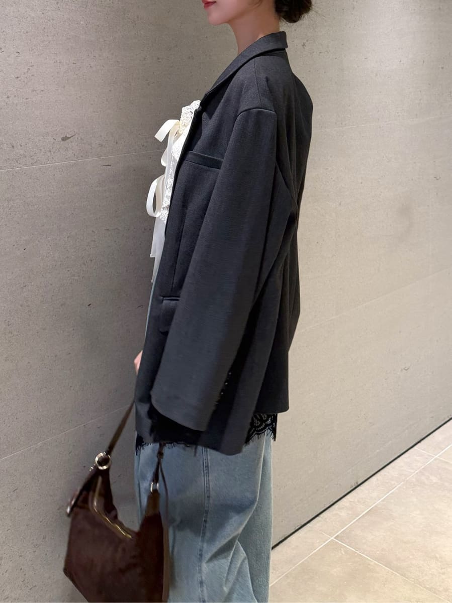 グレー系のテーラードジャケット、ブルー系のデニムパンツ、ホワイト系のその他トップスを着用したレディースの夏コーディネートの4枚目の写真