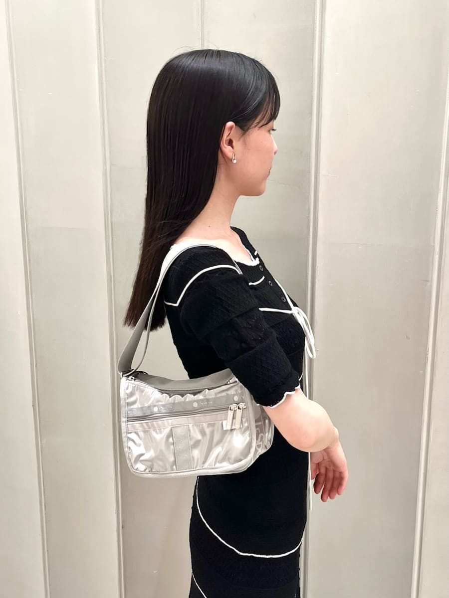 ブラック系のパンプス、ブラック系のワンピース、シルバー系のショルダーバッグを着用したレディースの春コーディネートの4枚目の写真