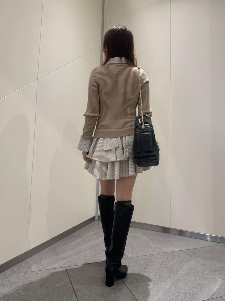 ベージュ系のワンピース、ブラック系のブーツ、ブラック系のショルダーバッグを着用したレディースの秋コーディネートの3枚目の写真