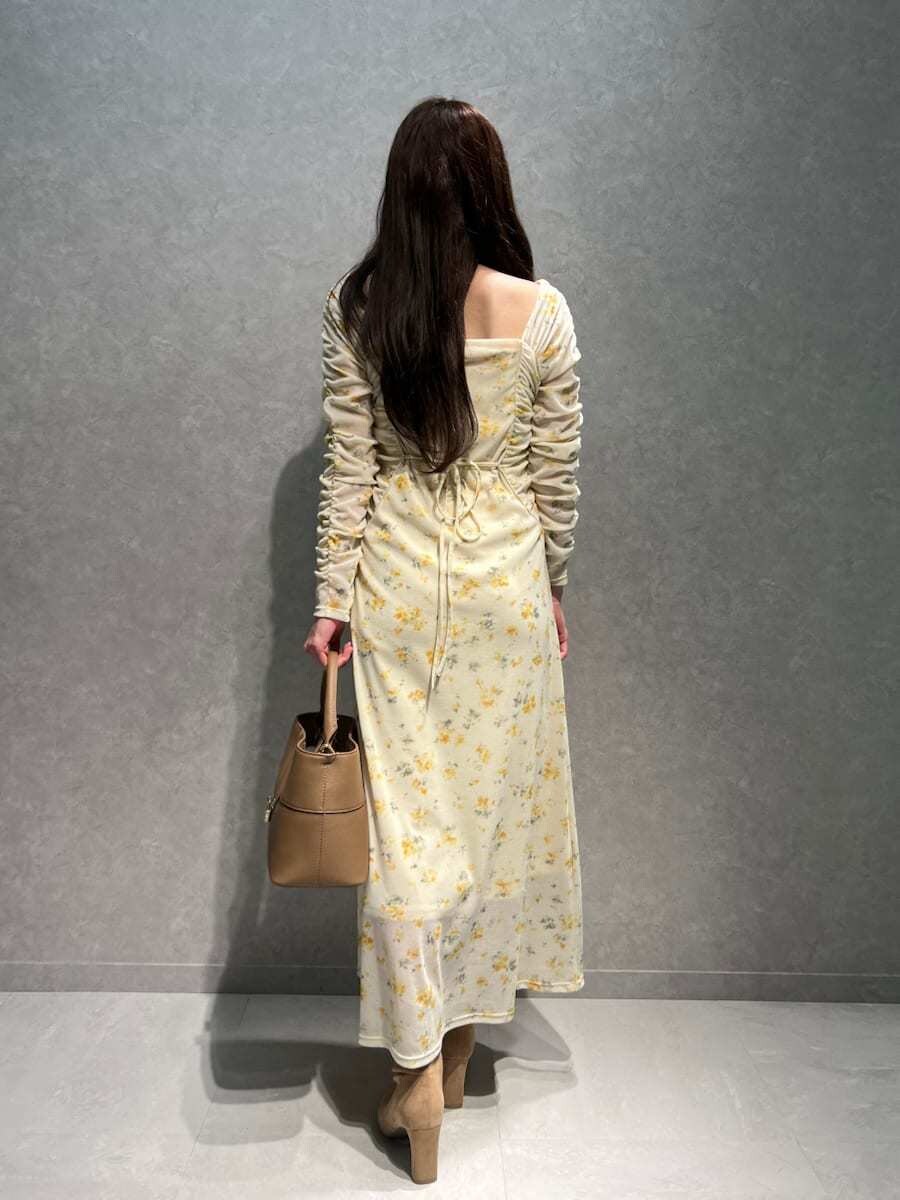 ベージュ系のブーツ、イエロー系のワンピース、イエロー系のハンドバッグを着用したレディースの冬コーディネートの6枚目の写真