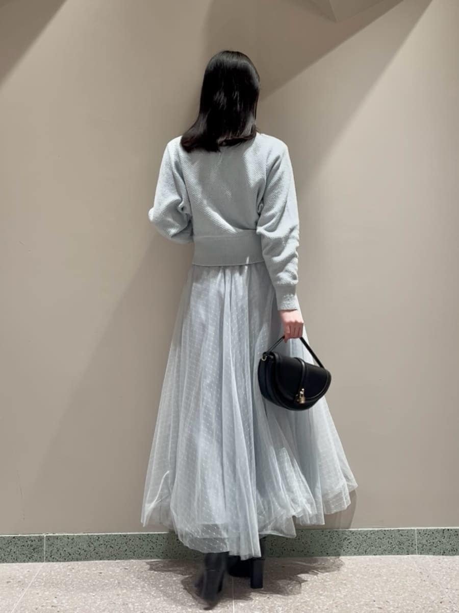 ブラック系のブーツ、ブラック系のハンドバッグ、ブルー系のワンピースを着用したレディースの冬コーディネートの4枚目の写真