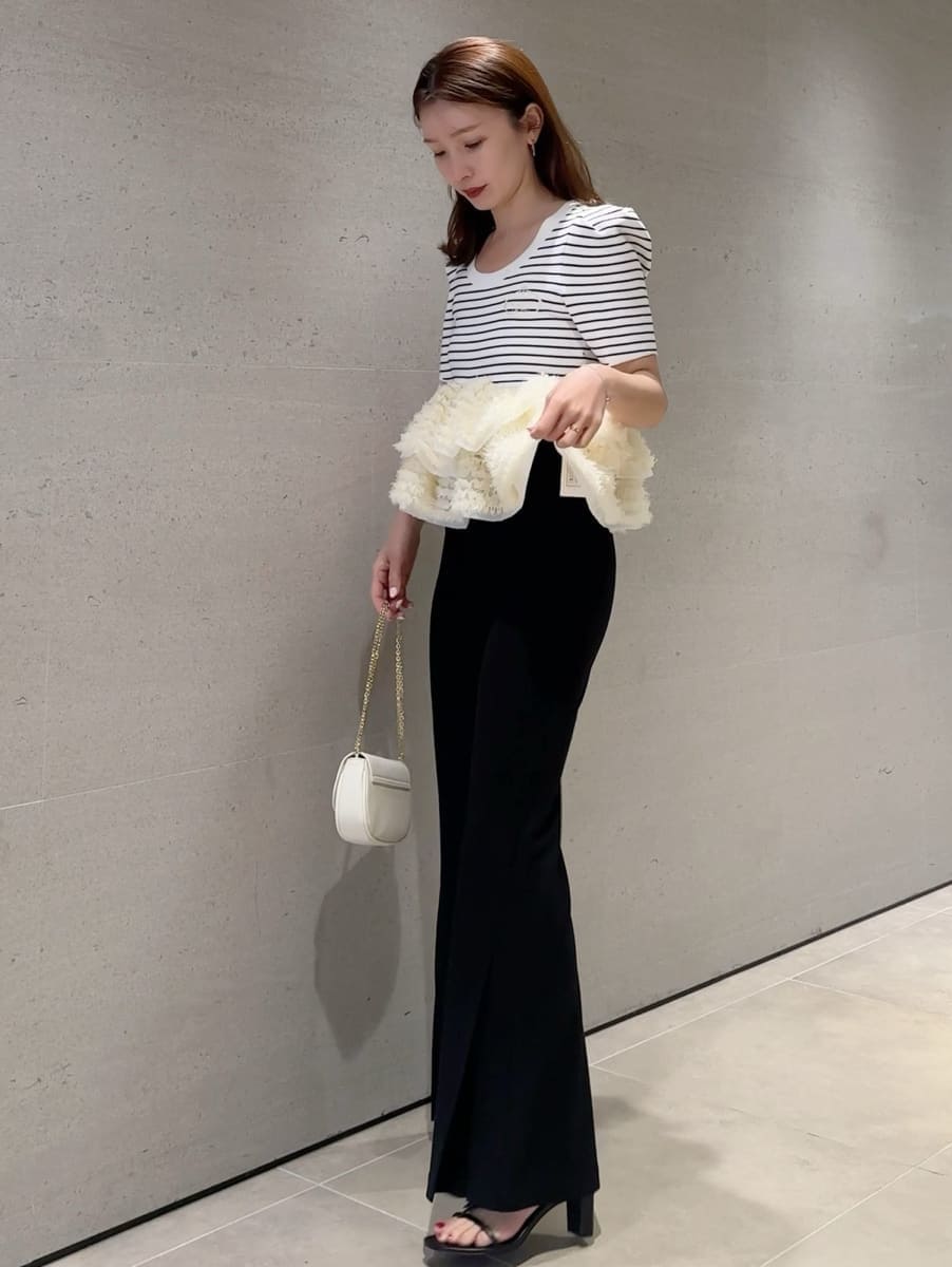 ブラック系のその他パンツ、その他のニット/セーター、ホワイト系のショルダーバッグを着用したレディースの春コーディネートの3枚目の写真