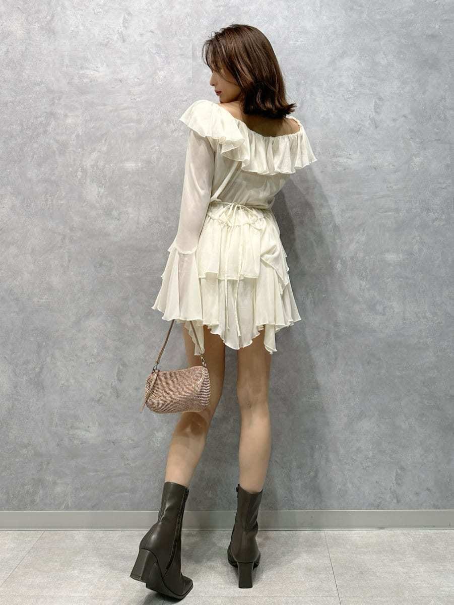 グレー系のステンカラーコート、ホワイト系のワンピースを着用したレディースの秋コーディネートの4枚目の写真