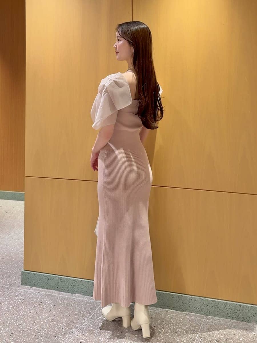 ピンク系のワンピース、ベージュ系のハンドバッグ、ホワイト系のネックレスを着用したレディースの春コーディネートの3枚目の写真