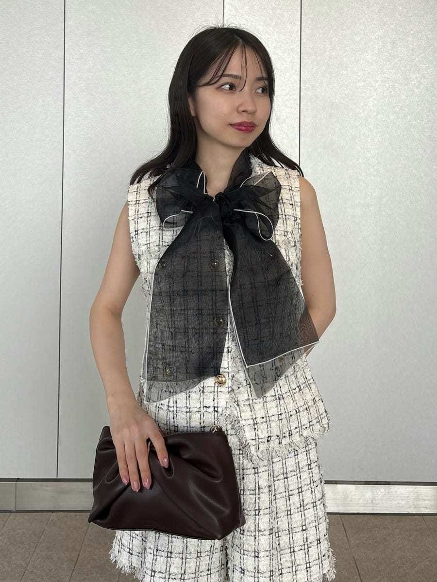 ホワイト系のベスト、ホワイト系のその他パンツ、ブラック系のニット/セーターを着用したレディースの夏コーディネートの6枚目の写真