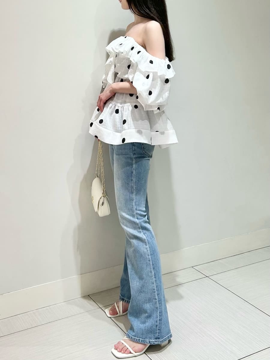 ブルー系のデニムパンツ、ホワイト系のショルダーバッグ、ホワイト系のシャツ/ブラウスを着用したレディースの春コーディネートの2枚目の写真