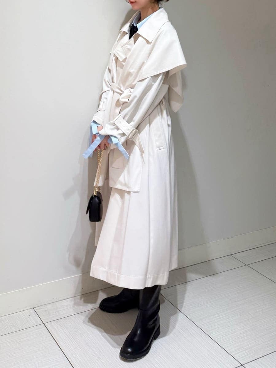 ホワイト系のトレンチコート、グレー系のスカート、ブルー系のニット/セーターを着用したレディースの冬コーディネートの2枚目の写真