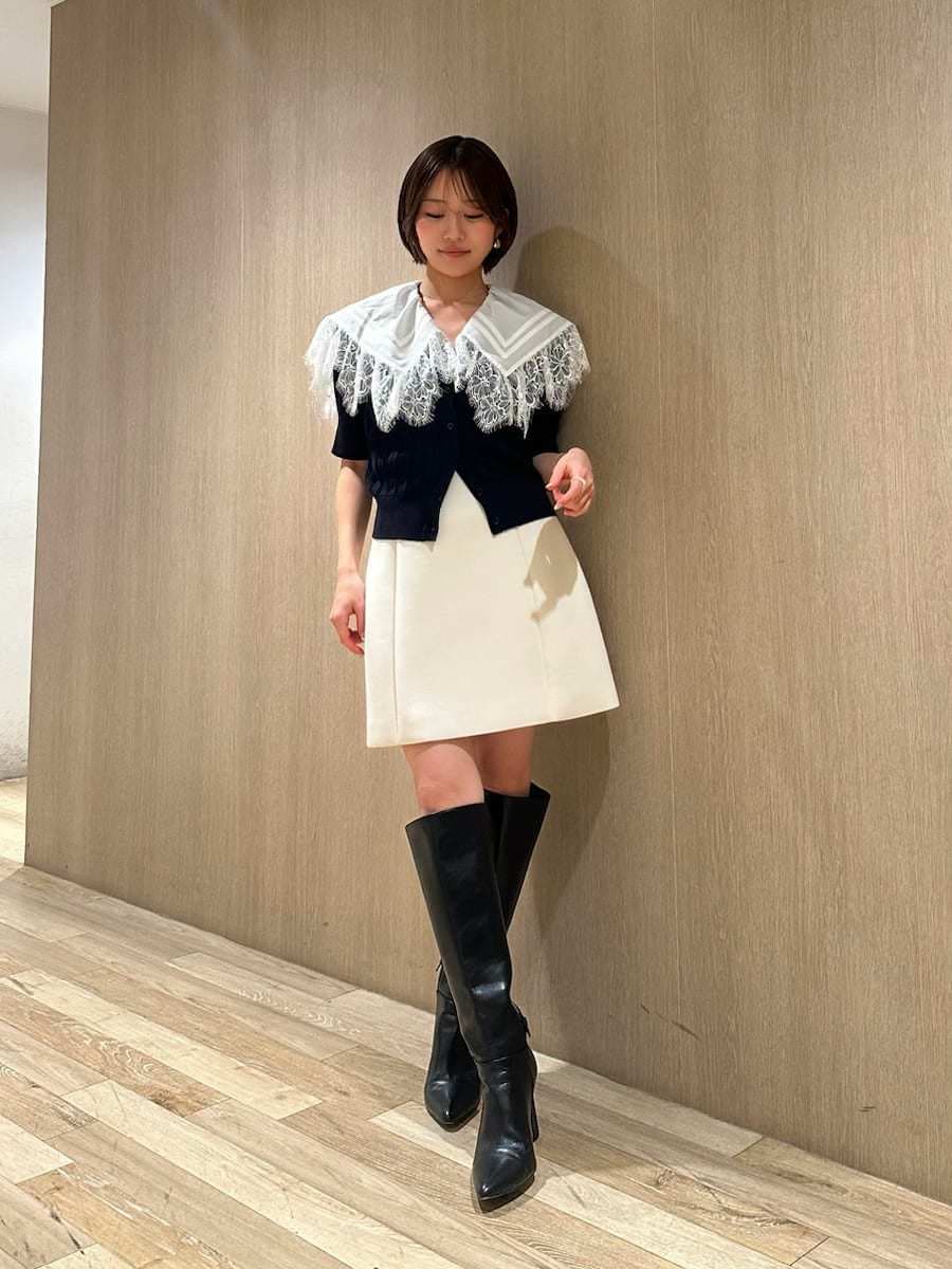 ブラック系のブーツ、ホワイト系のスカート、ブルー系のカーディガン/ボレロを着用したレディースの春コーディネートの6枚目の写真