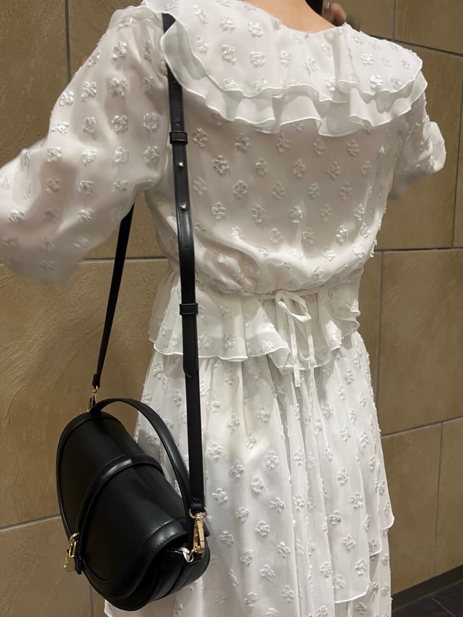 ブラック系のブーツ、ブラック系のハンドバッグ、シルバー系のスカートを着用したレディースの冬コーディネートの5枚目の写真