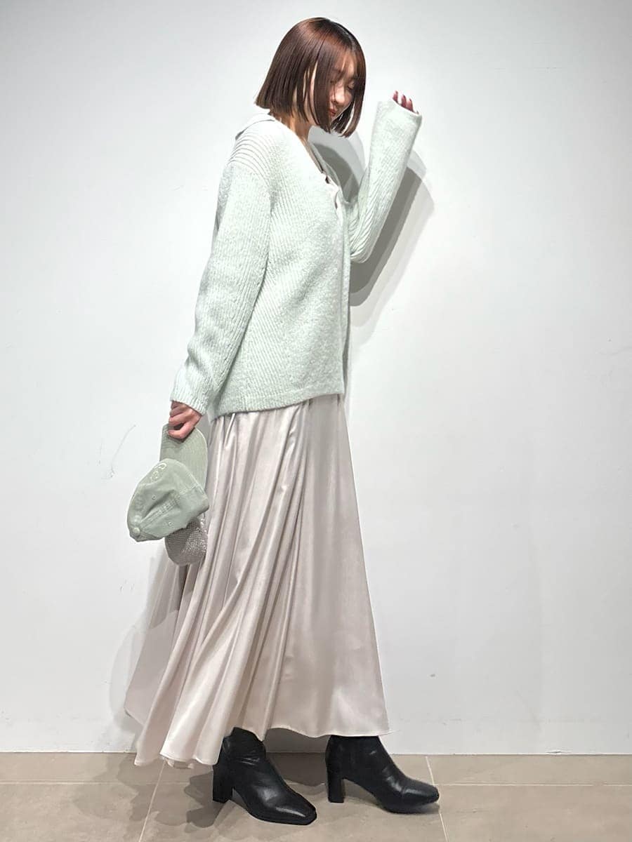 グレー系のブーツ、グリーン系のワンピース、グリーン系のキャップを着用したレディースの冬コーディネートの6枚目の写真