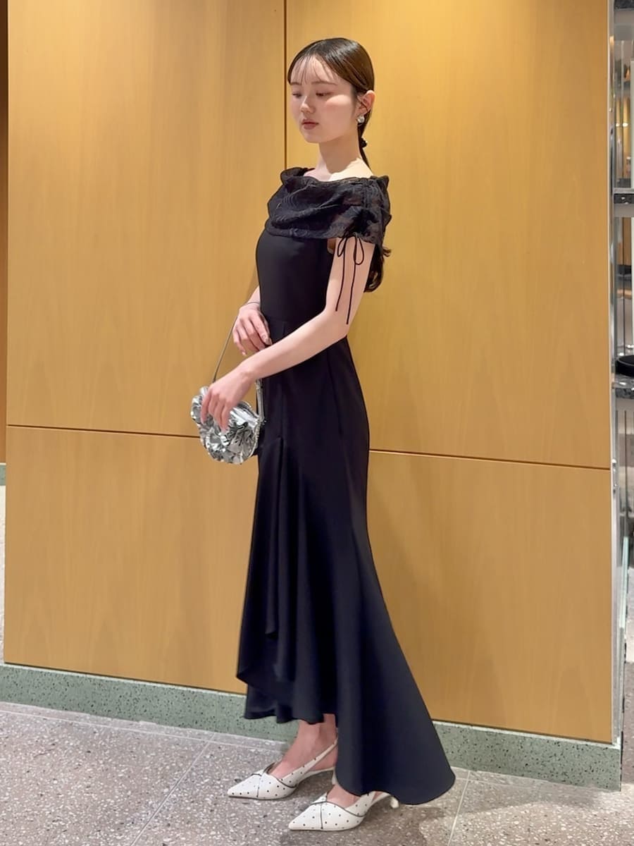 ブラック系のドレス、その他のパンプス、シルバー系のハンドバッグを着用したレディースの春コーディネートの2枚目の写真