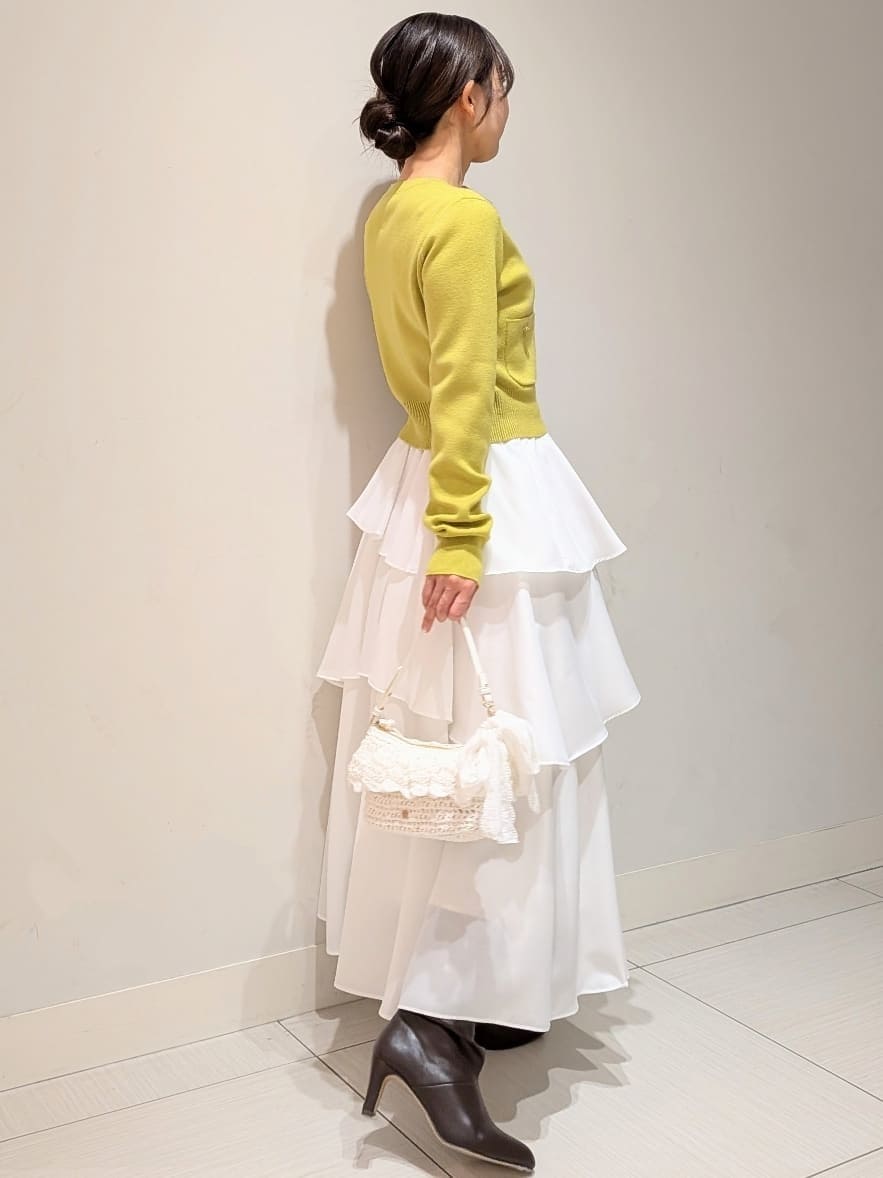 ブラック系のブーツ、イエロー系のワンピースを着用したレディースの冬コーディネートの2枚目の写真