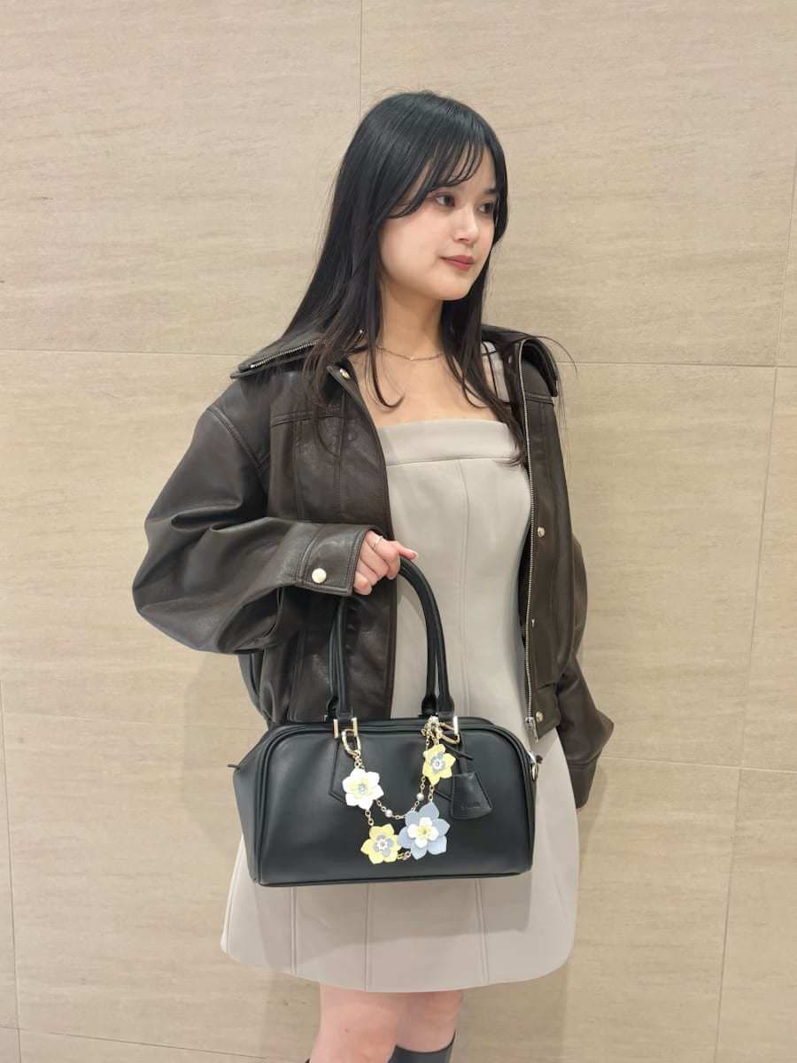 ブラウン系のブルゾン、グリーン系のワンピース、イエロー系のボストンバッグを着用したレディースの冬コーディネートの4枚目の写真