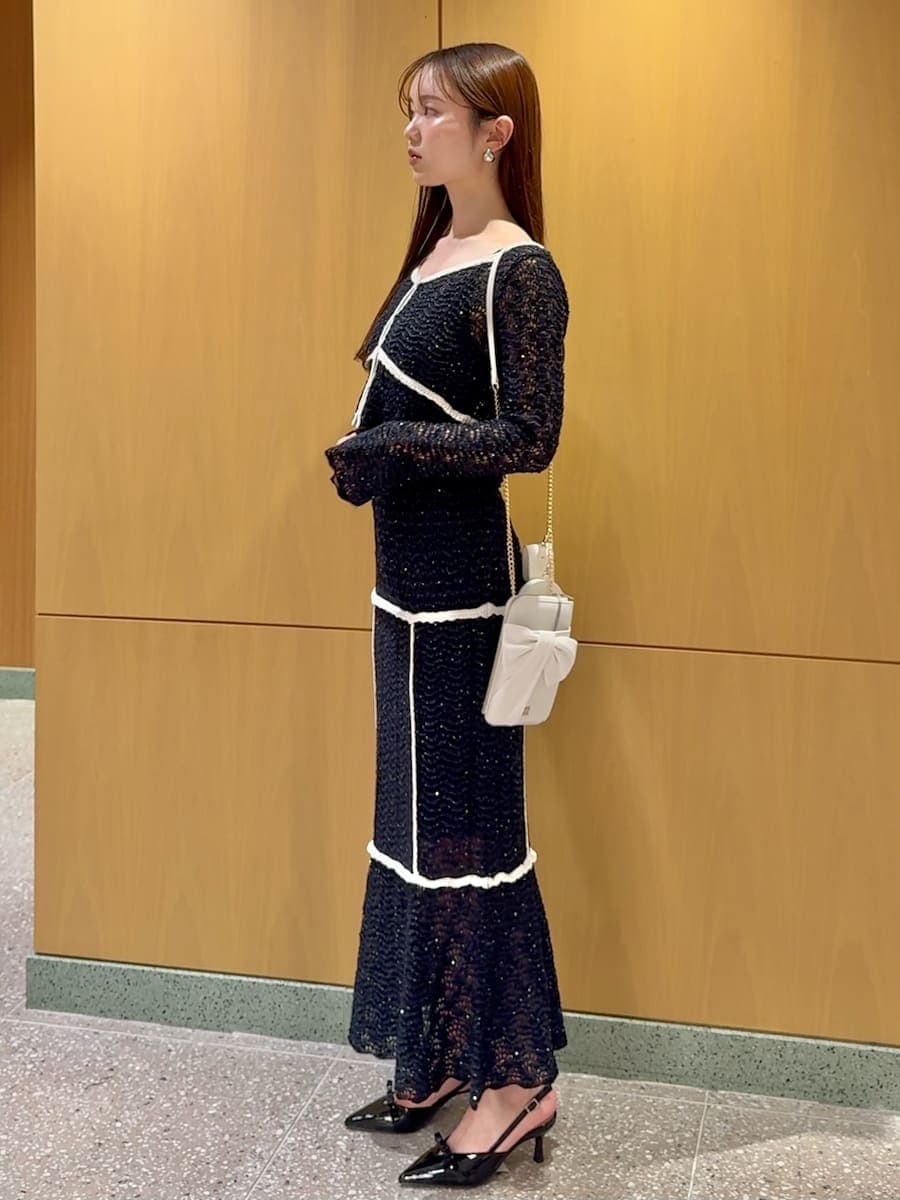 ブルー系のスカート、ブルー系のニット/セーター、ホワイト系のショルダーバッグを着用したレディースの春コーディネートの2枚目の写真