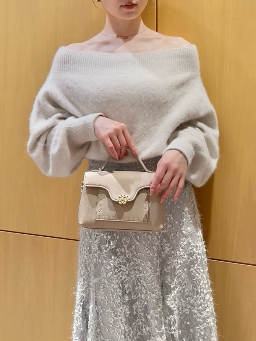 ホワイト系のニット/セーター、グリーン系のスカート、ベージュ系のブーツを着用したレディースの秋コーディネートの7枚目の写真