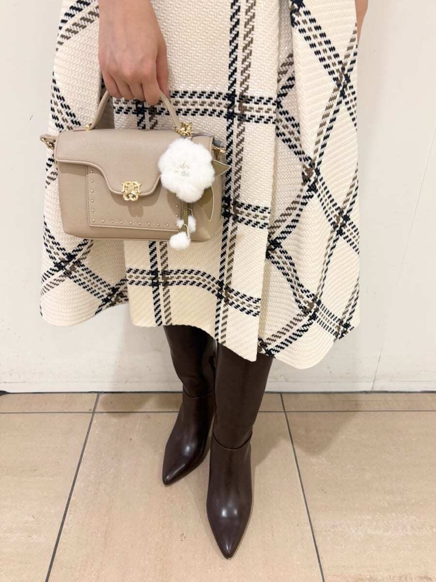 ブラウン系のニット/セーター、ホワイト系のスカート、ブラウン系のブーツを着用したレディースの秋コーディネートの7枚目の写真