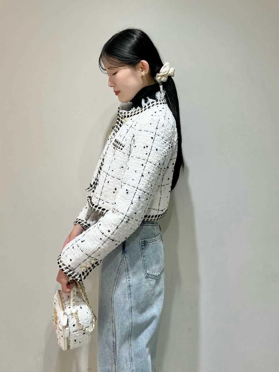 ホワイト系のノーカラージャケット、ブルー系のデニムパンツ、ブラック系のニット/セーターを着用したレディースの秋コーディネートの5枚目の写真