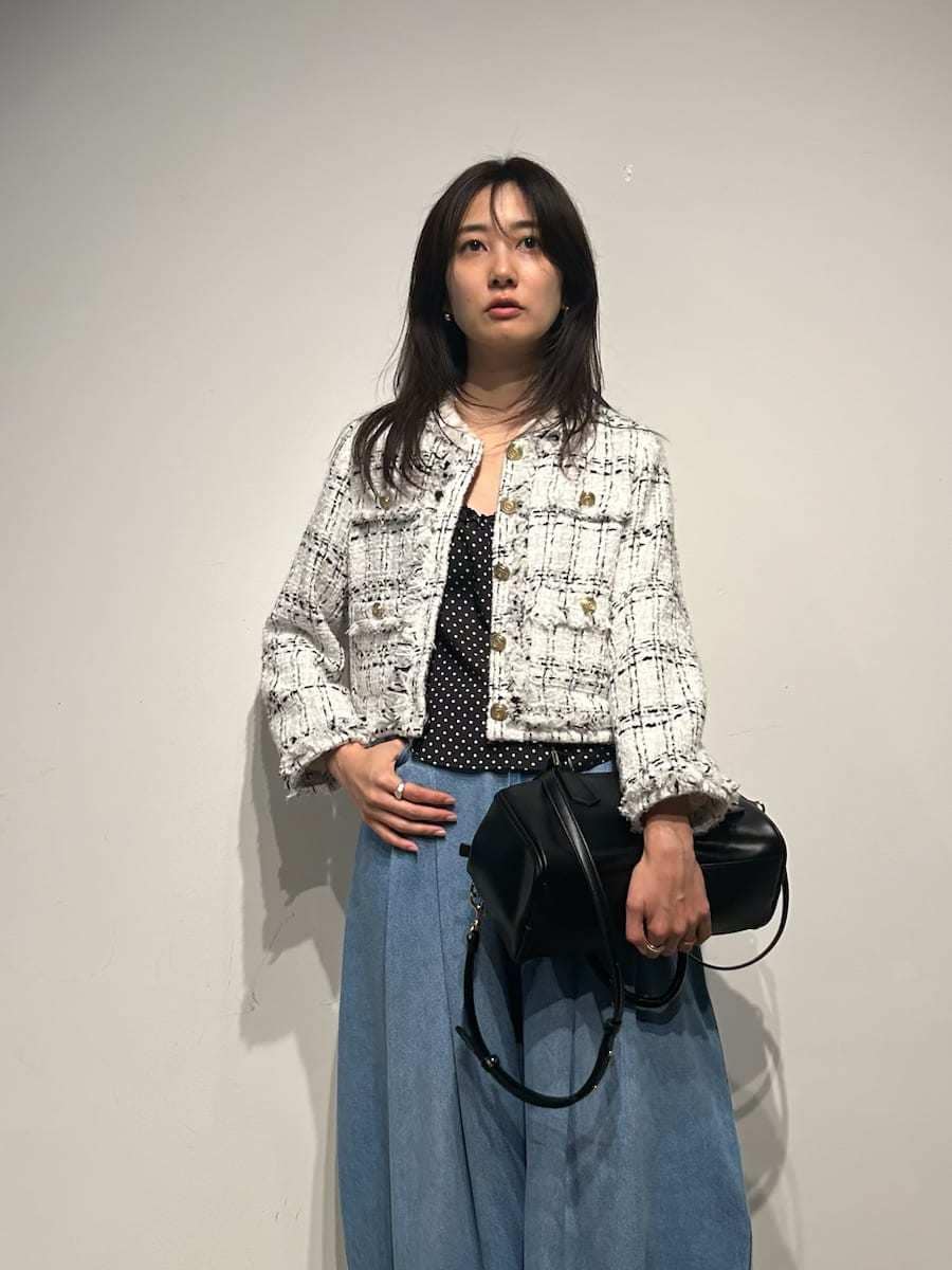 ホワイト系のノーカラージャケット、ブラック系のキャミソール、ブラック系のパンプスを着用したレディースの春コーディネートの5枚目の写真