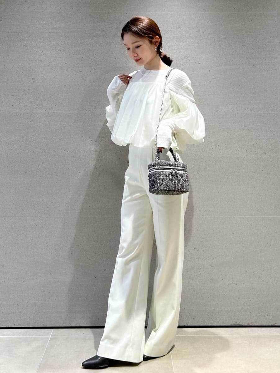 ブラウン系のブーツ、ホワイト系のスラックス、ホワイト系のニット/セーターを着用したレディースの秋コーディネートの4枚目の写真