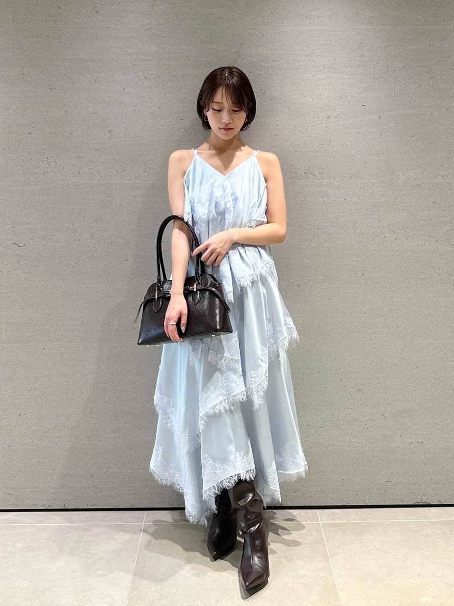 ブルー系のワンピース、ブラウン系のブーツ、ブラウン系のボストンバッグを着用したレディースの夏コーディネートの6枚目の写真
