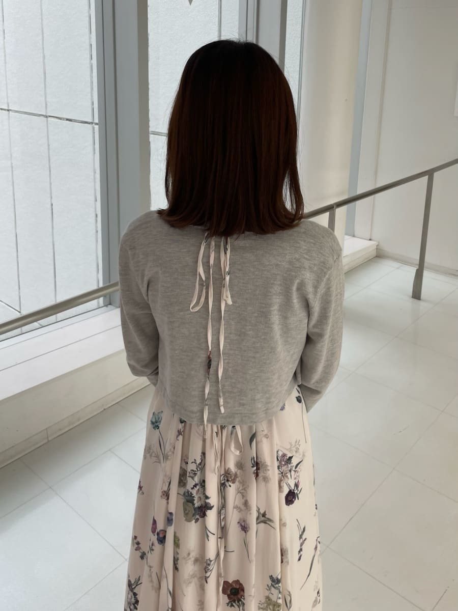 ブラウン系のブーツ、ホワイト系のワンピース、ホワイト系のボストンバッグを着用したレディースの冬コーディネートの5枚目の写真