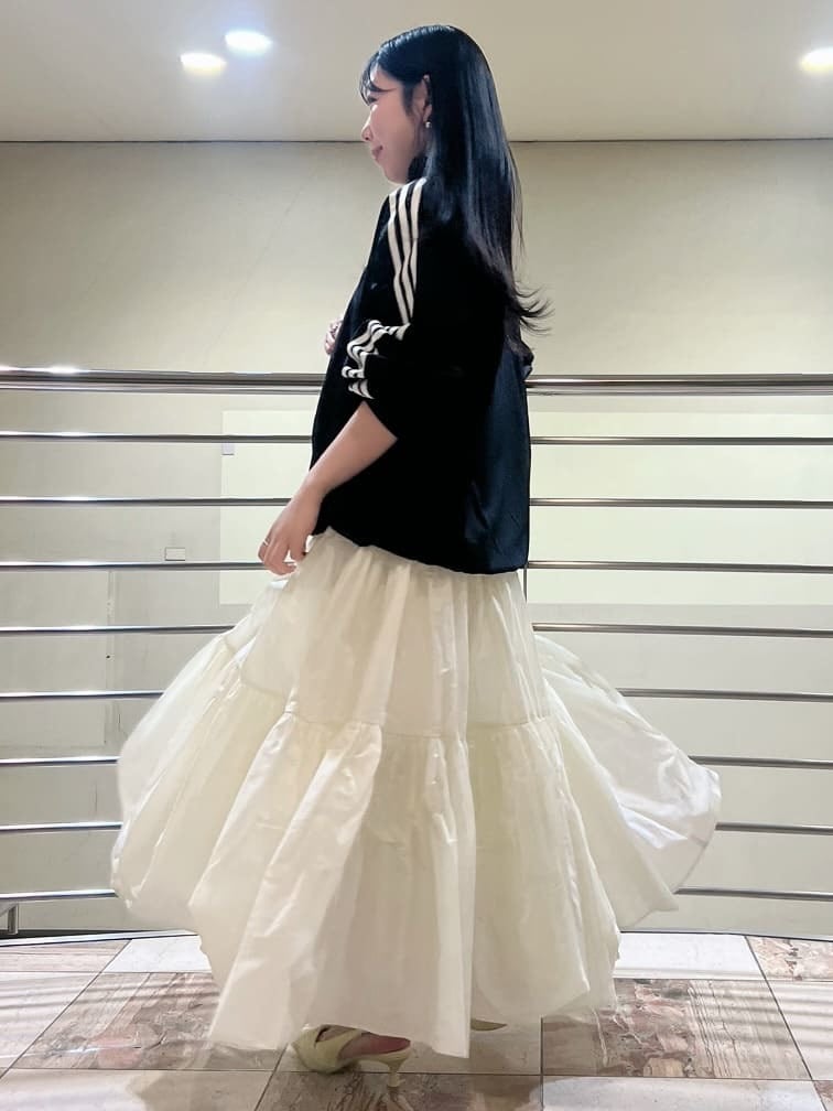 ホワイト系のスカート、ブラック系のブルゾン、イエロー系のパンプスを着用したレディースの春コーディネートの3枚目の写真