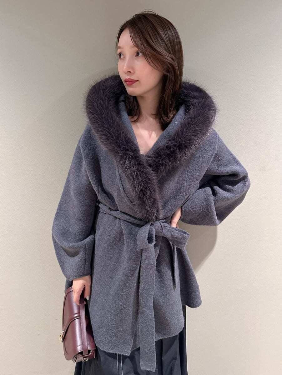 ブラック系のワンピース、ブラウン系のハンドバッグ、ブラック系のブーツを着用したレディースの秋コーディネートの6枚目の写真