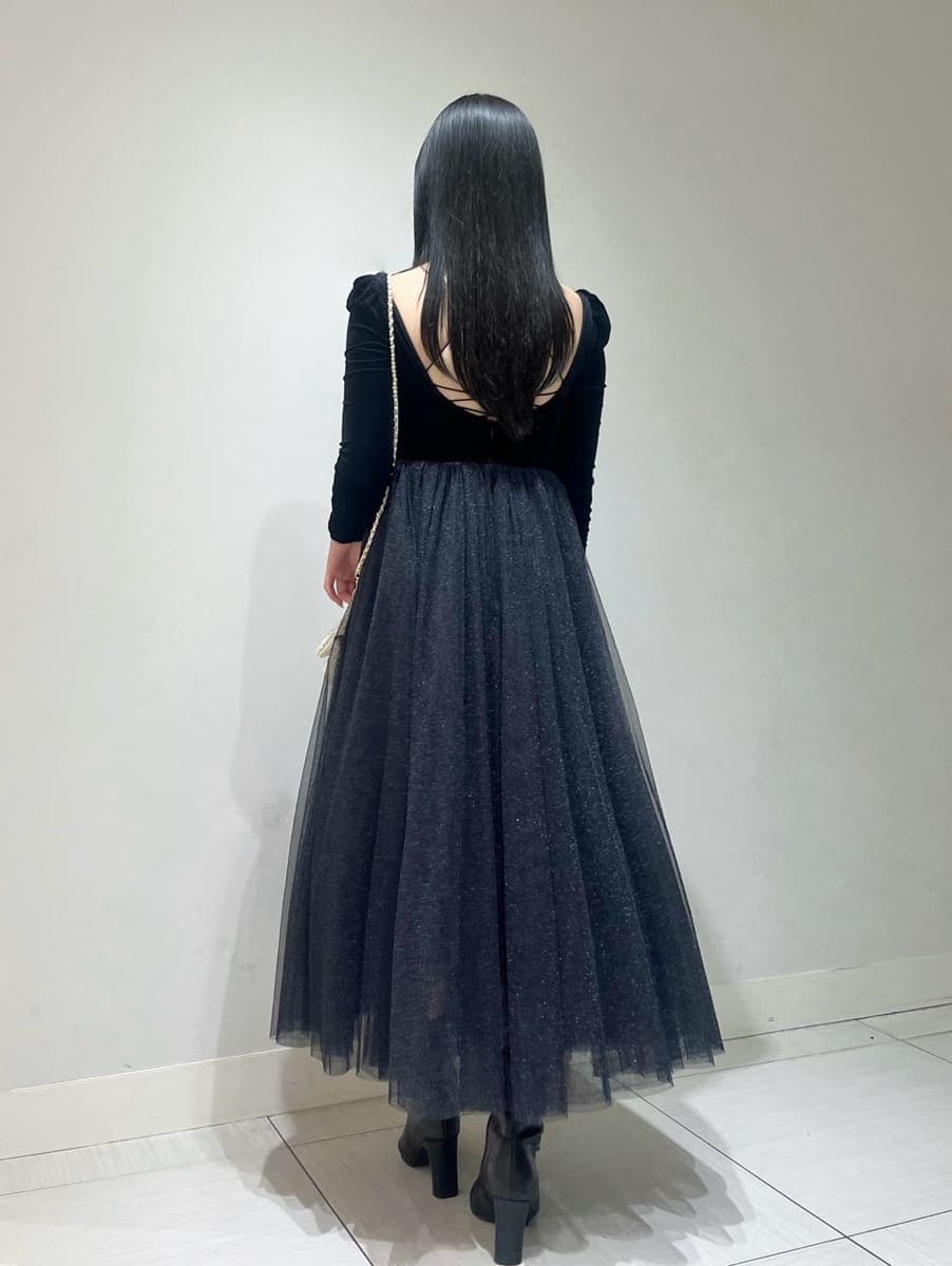 ブラック系のワンピース、ホワイト系のショルダーバッグ、ブラック系のブーツを着用したレディースの夏コーディネートの2枚目の写真