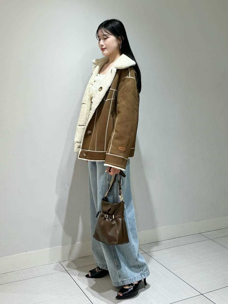 ブルー系のデニムパンツ、ブラック系のサンダル、ブラウン系のショルダーバッグを着用したレディースの秋コーディネートの2枚目の写真