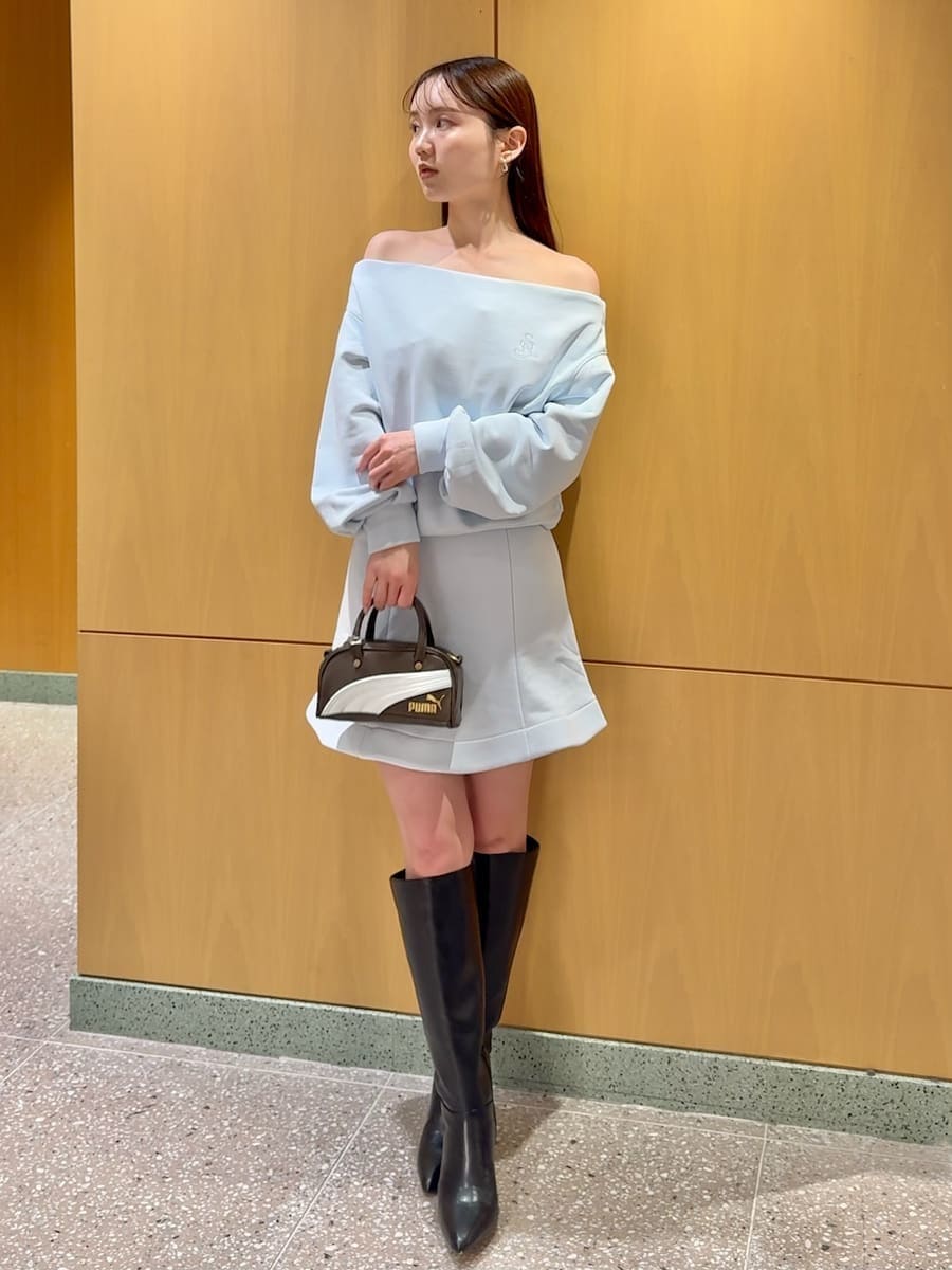 ブラック系のブーツ、ホワイト系のダウンジャケット/コート、ブルー系のワンピースを着用したレディースの冬コーディネートの4枚目の写真