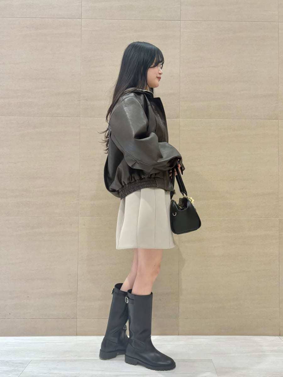 ブラウン系のブルゾン、グリーン系のワンピース、イエロー系のボストンバッグを着用したレディースの冬コーディネートの2枚目の写真