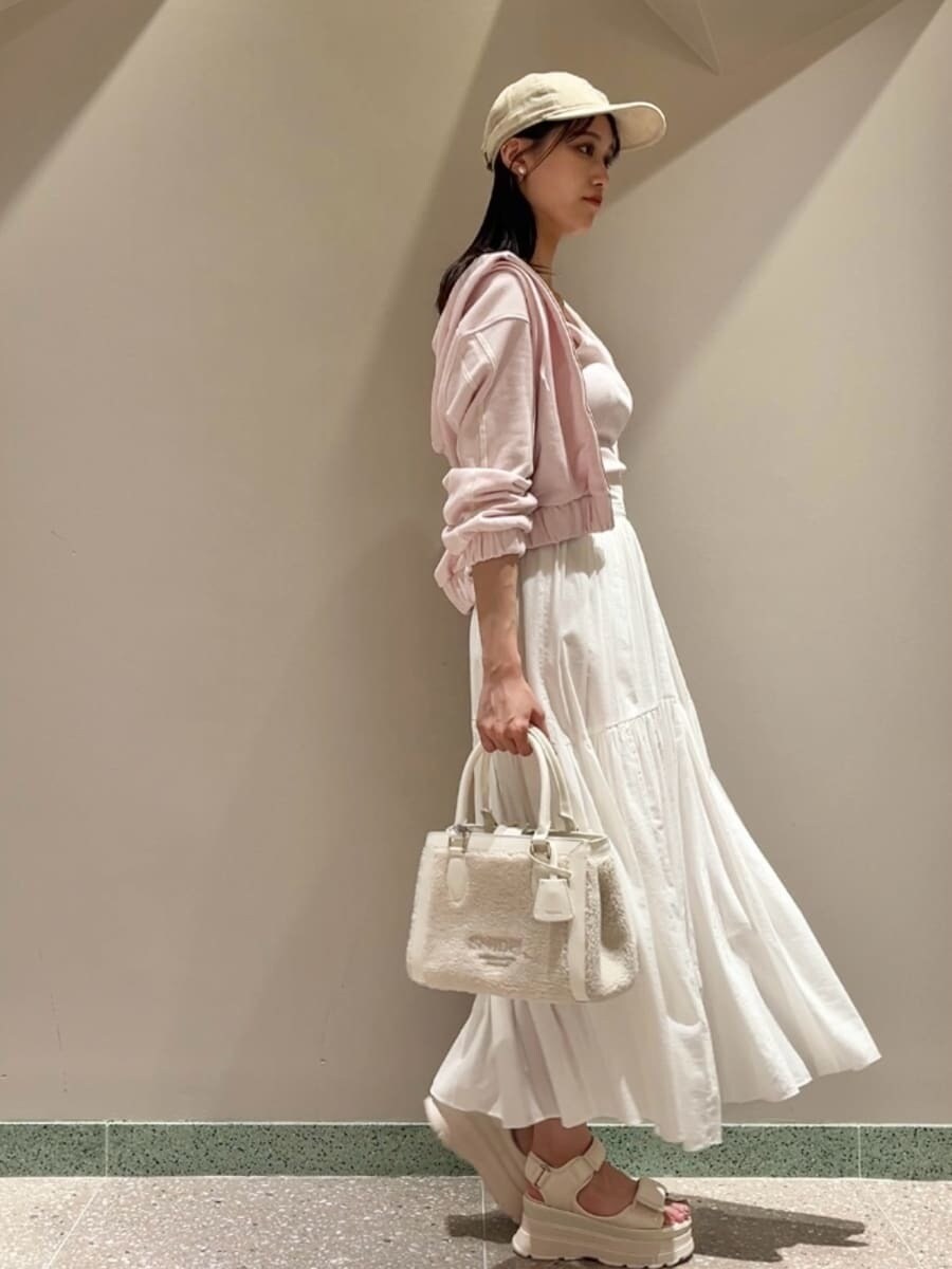 ピンク系のパーカー、ピンク系のタンクトップ、ホワイト系のスカートを着用したレディースの夏コーディネートの6枚目の写真