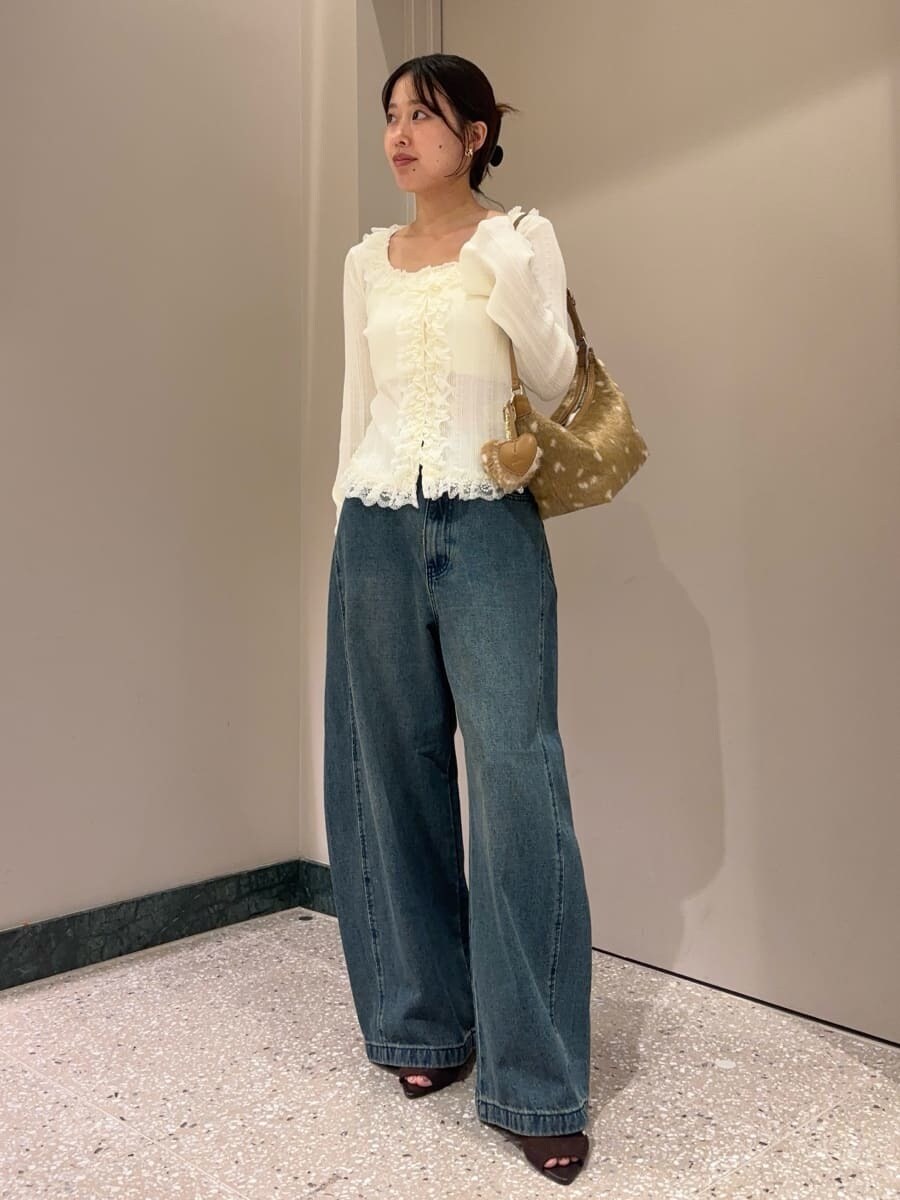 ブルー系のデニムパンツ、ホワイト系のニット/セーター、ブラウン系のサンダルを着用したレディースの夏コーディネートの2枚目の写真