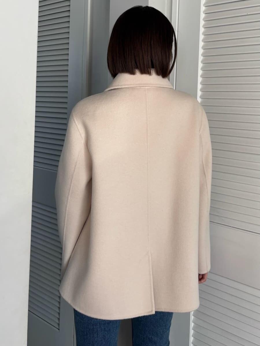 ブルー系のデニムパンツ、ブラウン系のハンドバッグを着用したレディースの秋コーディネートの4枚目の写真