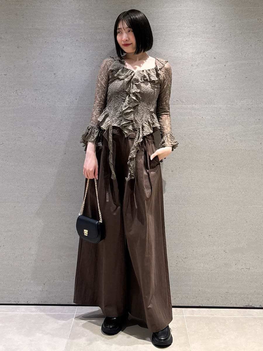ブラウン系のその他パンツ、グリーン系のTシャツ/カットソー、ブラック系のショルダーバッグを着用したレディースの冬コーディネートの2枚目の写真