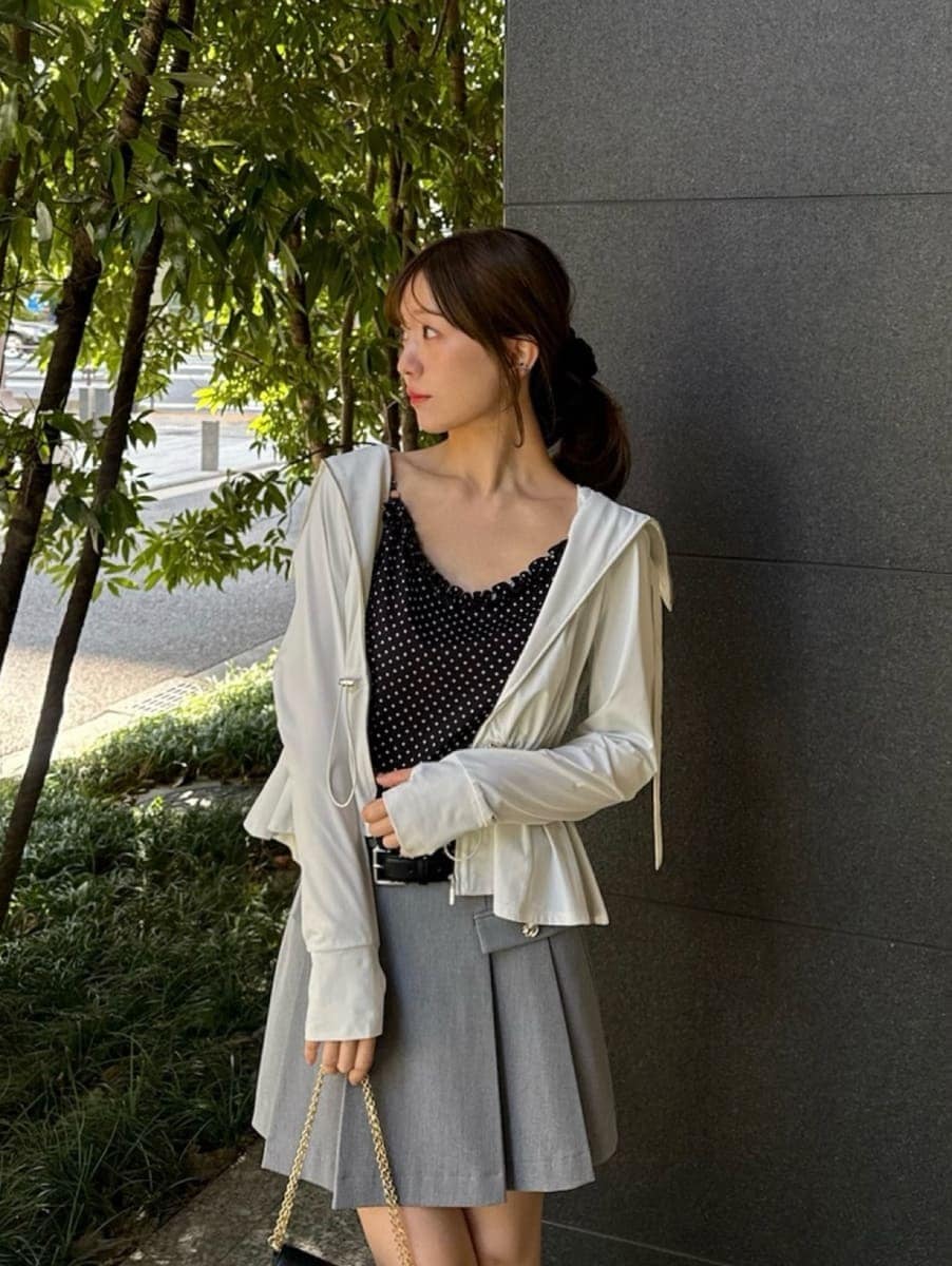 グレー系のスカート、ブラック系のキャミソール、ブラック系のショルダーバッグを着用したレディースの春コーディネートの4枚目の写真