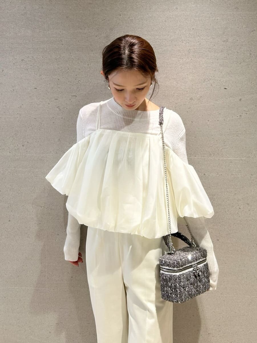 ブラウン系のブーツ、ホワイト系のスラックス、ホワイト系のニット/セーターを着用したレディースの秋コーディネートの3枚目の写真