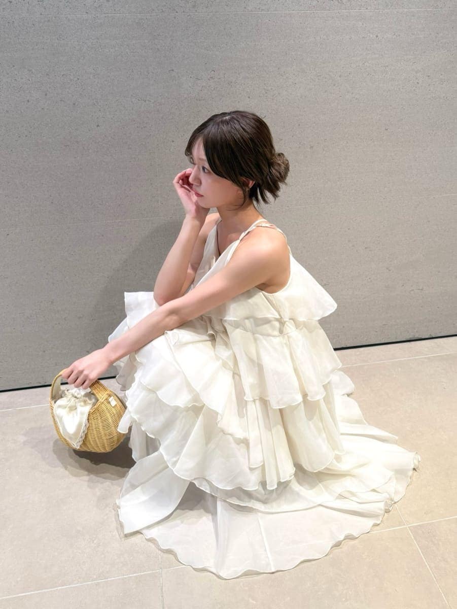 ホワイト系のかごバッグ、ホワイト系のテーラードジャケット、ホワイト系のドレスを着用したレディースの夏コーディネートの4枚目の写真