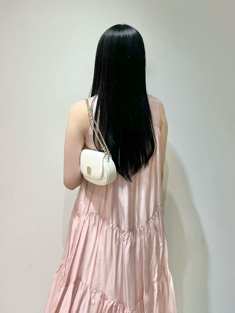 ホワイト系のショルダーバッグ、ピンク系のワンピース、その他のサンダルを着用したレディースの夏コーディネートの6枚目の写真