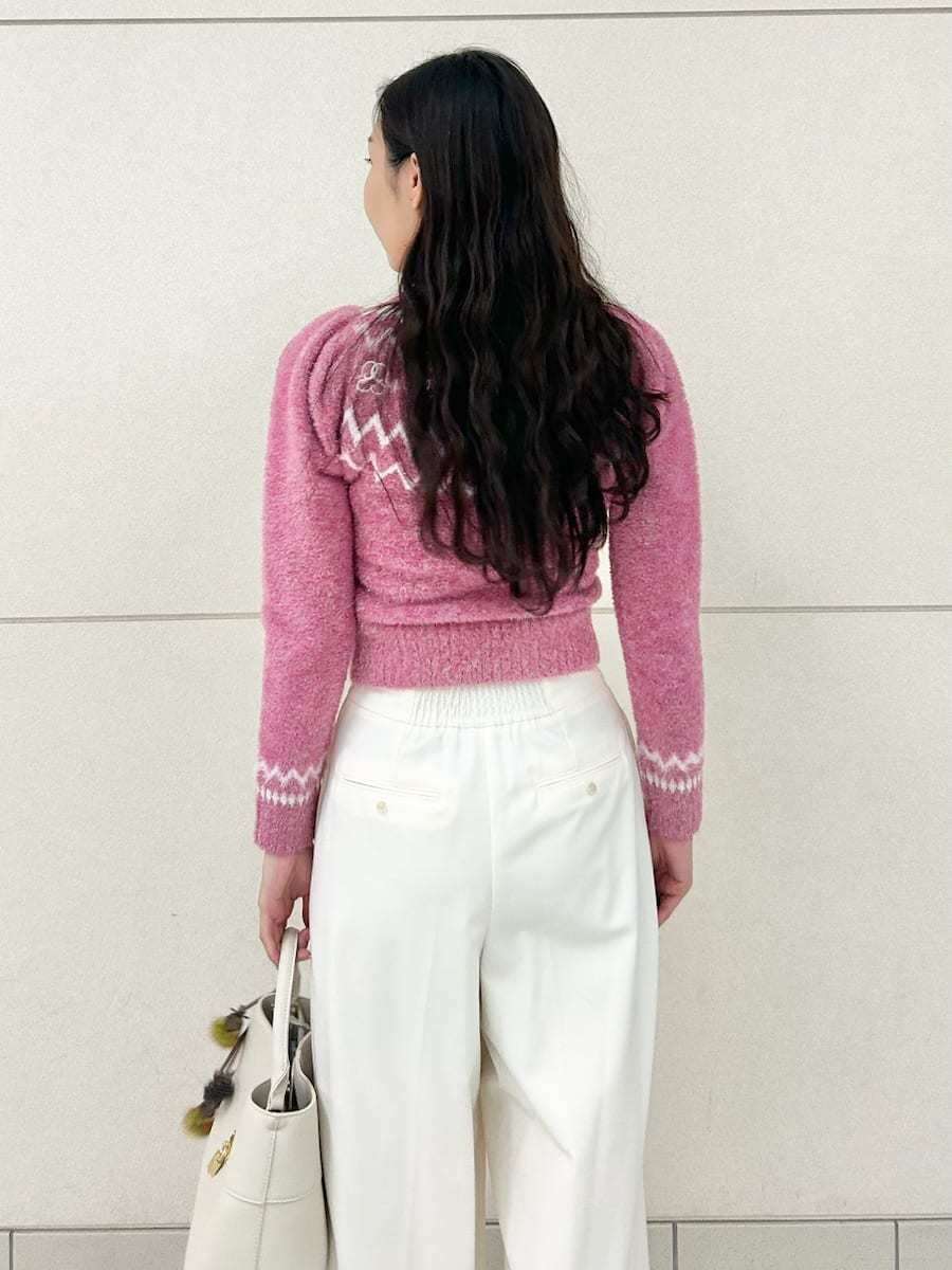 ベージュ系のブーツ、ホワイト系のスラックス、ピンク系のニット/セーターを着用したレディースの冬コーディネートの7枚目の写真