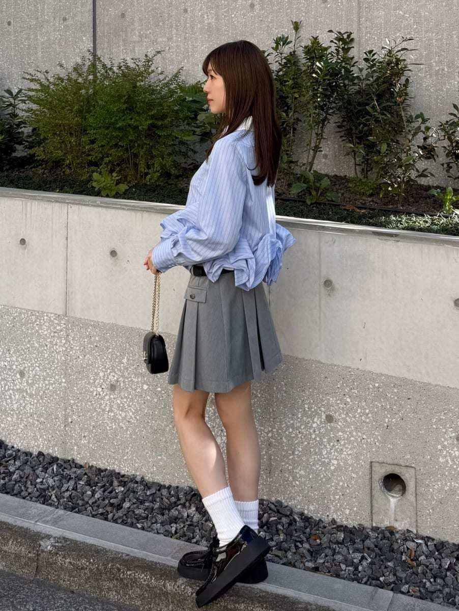 グレー系のスカート、その他のシャツ/ブラウス、ブラック系のショルダーバッグを着用したレディースの冬コーディネートの3枚目の写真