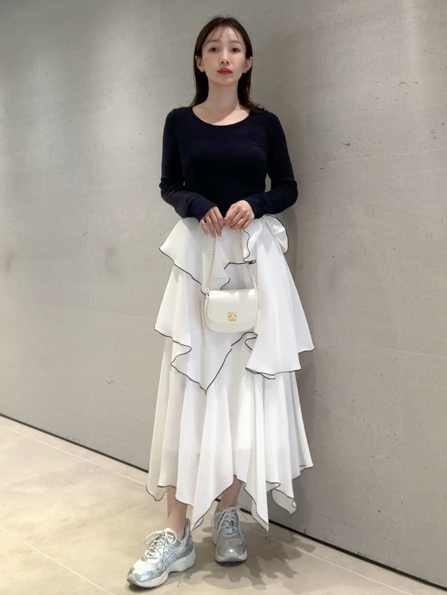 ブルー系のワンピース、ホワイト系のショルダーバッグ、シルバー系のスニーカーを着用したレディースの冬コーディネートの5枚目の写真