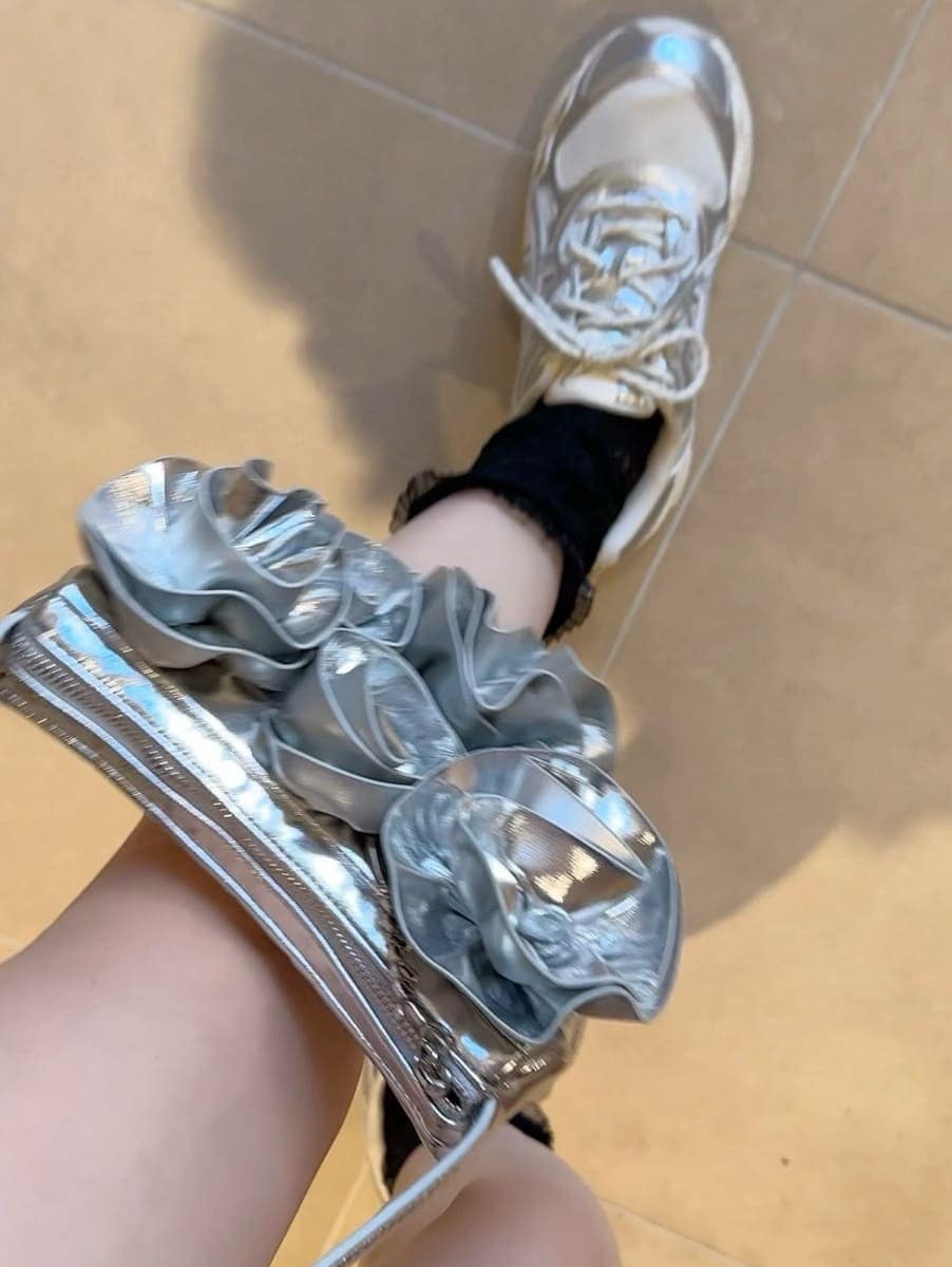 ブラック系のドレス、シルバー系のスニーカーを着用したレディースの冬コーディネートの3枚目の写真