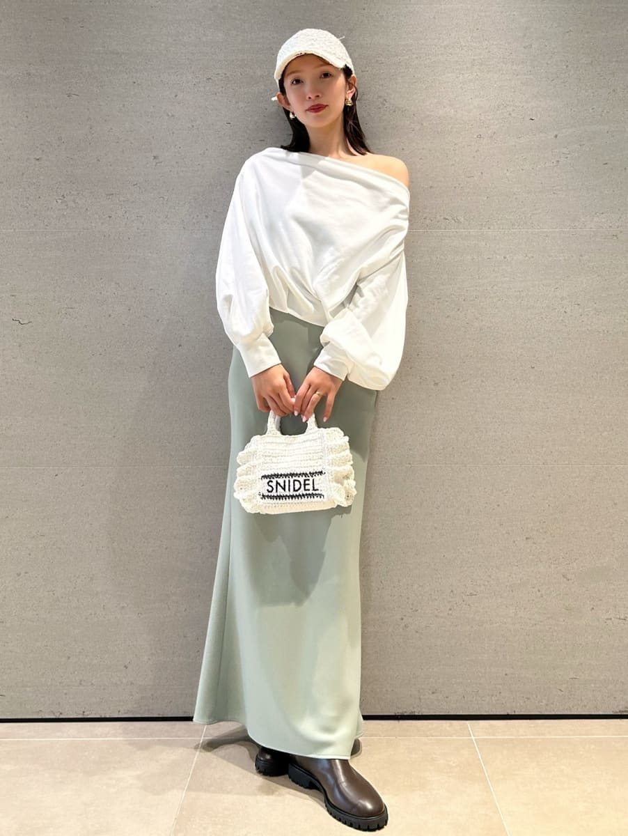 グリーン系のスカート、ホワイト系のスウェット、ホワイト系のショルダーバッグを着用したレディースの春コーディネートの4枚目の写真