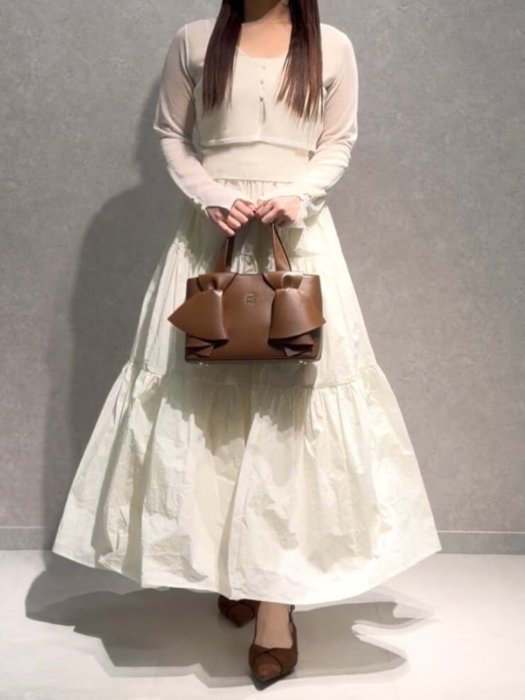 ホワイト系のワンピース、ブラウン系のパンプス、ブラウン系のハンドバッグを着用したレディースの春コーディネートの2枚目の写真