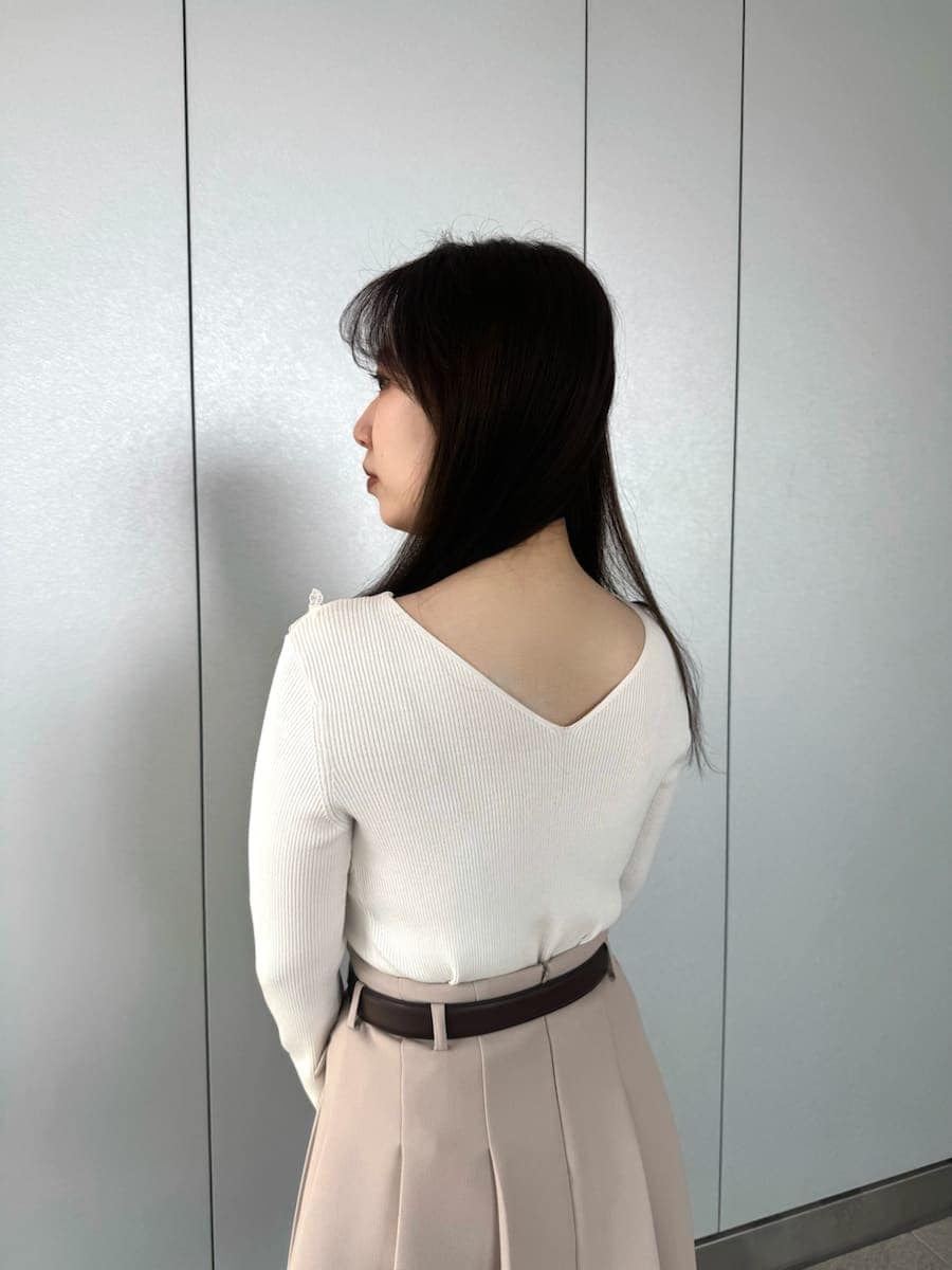 ベージュ系のスカート、ホワイト系のショルダーバッグ、ベージュ系のキーケース/キーアクセサリーを着用したレディースの冬コーディネートの4枚目の写真