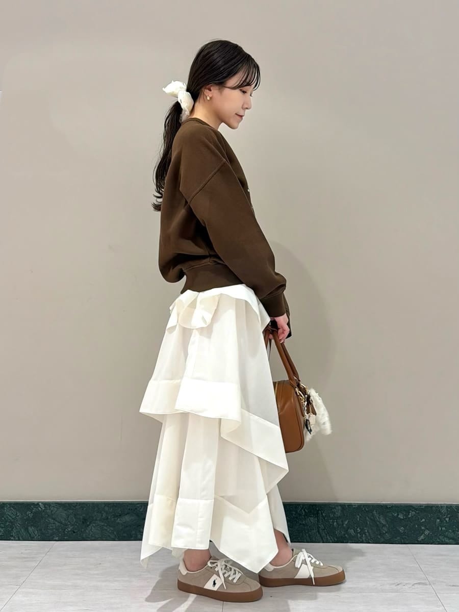 ホワイト系のスカート、ブラウン系のスウェット、イエロー系のボストンバッグを着用したレディースの春コーディネートの4枚目の写真