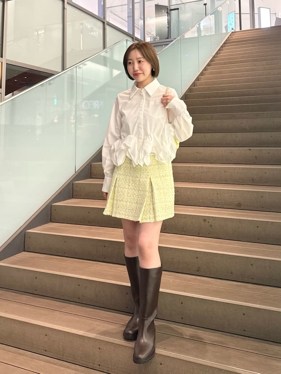 イエロー系のスカート、ホワイト系のシャツ/ブラウス、イエロー系のショルダーバッグを着用したレディースの冬コーディネートの10枚目の写真